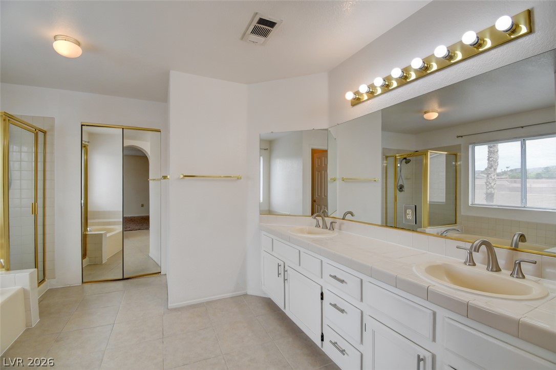 5 Tarryall Terrace Henderson, NV 89074 - Photo 39 of 44 A generously proportioned bathroom with dual vanities and bright lighting ensures a comfortable morning routine.
