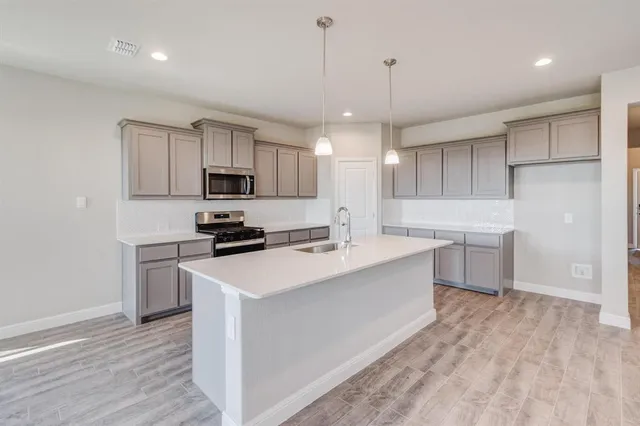 a kitchen with kitchen island a sink stainless steel appliances and cabinets