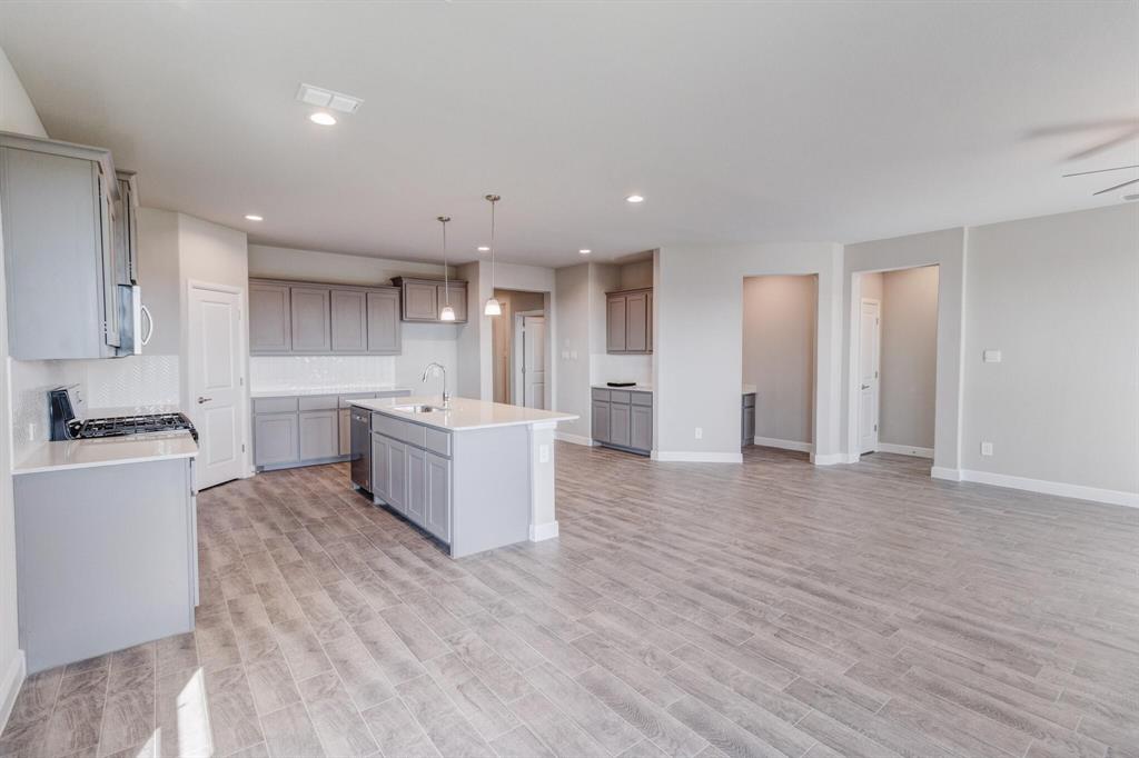 15524 Balham Pass Fort Worth, TX 76247 - Photo 8 of 10 a large kitchen with a large counter top a sink stainless steel appliances and cabinets