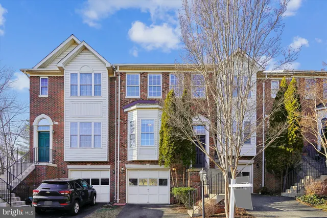 a car parked in front of a brick house with large windows