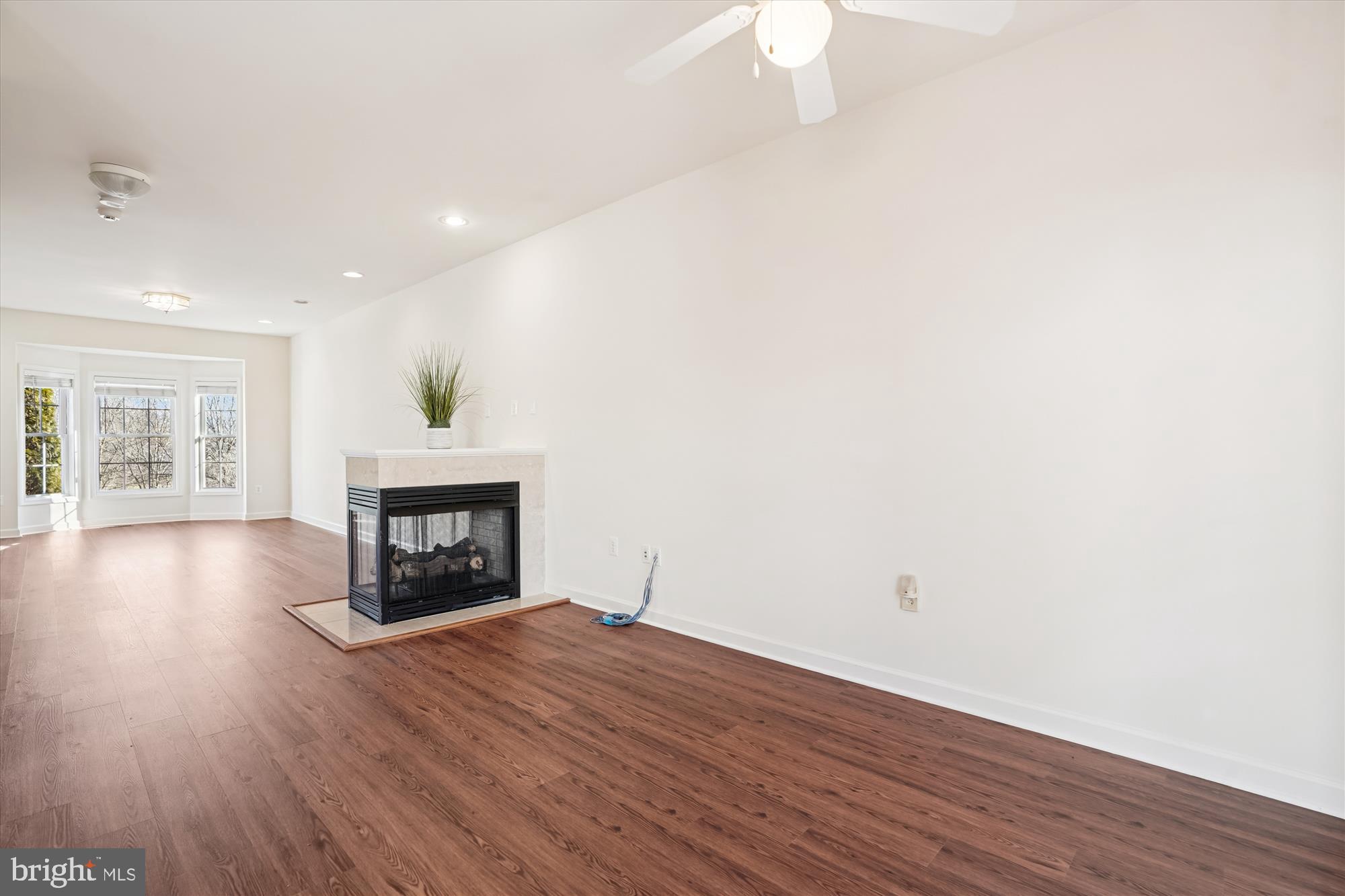 796 Col Edmonds Court Warrenton, VA 20186 - Photo 14 of 47 an empty room with wooden floor fire place and windows