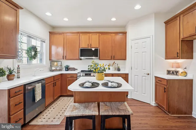 a kitchen with stainless steel appliances granite countertop a stove top oven a sink dishwasher and cabinets with wooden floor