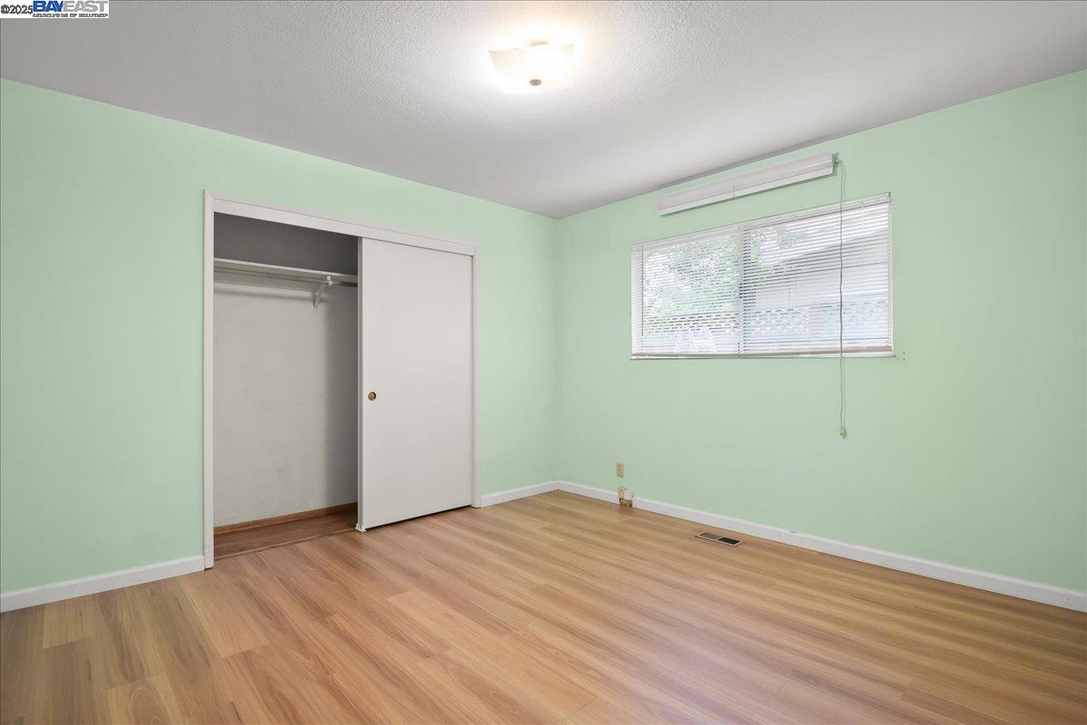 1043 Bonner Avenue Fremont, CA 94536 - Photo 12 of 16 an empty room with wooden floor and windows