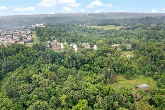 an aerial view of a city with lots of residential buildings and mountain view in back
