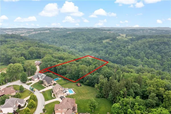 an aerial view of a houses with a yard and lake view