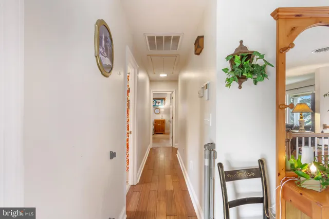 a view of a hallway to a livingroom with furniture