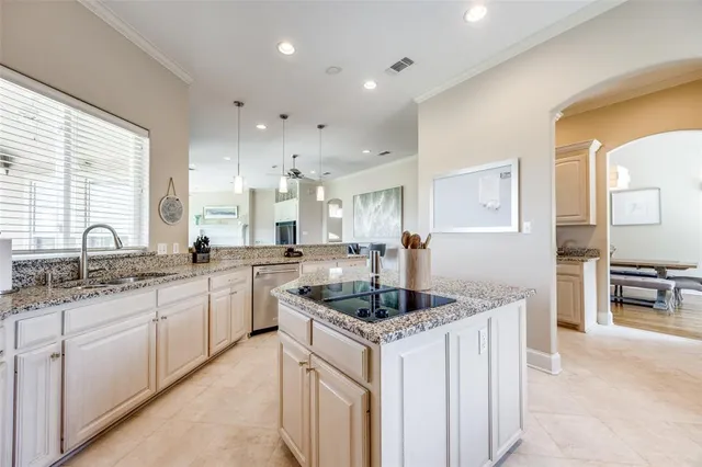 a kitchen with granite countertop a sink and white cabinets