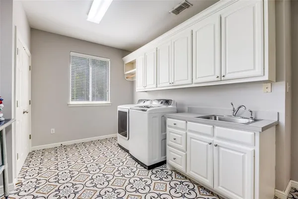 a utility room with sink dryer and washer