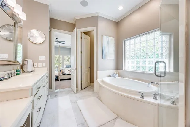 a spacious bathroom with a tub sink and mirror