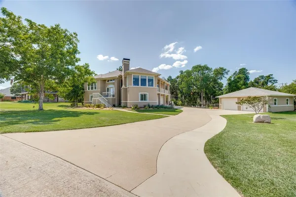a view of a house with a big yard plants and large trees