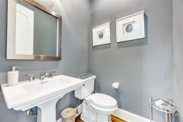 a bathroom with a toilet a sink and mirror