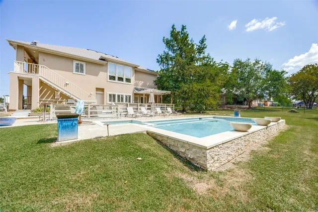 a swimming pool with outdoor seating and yard