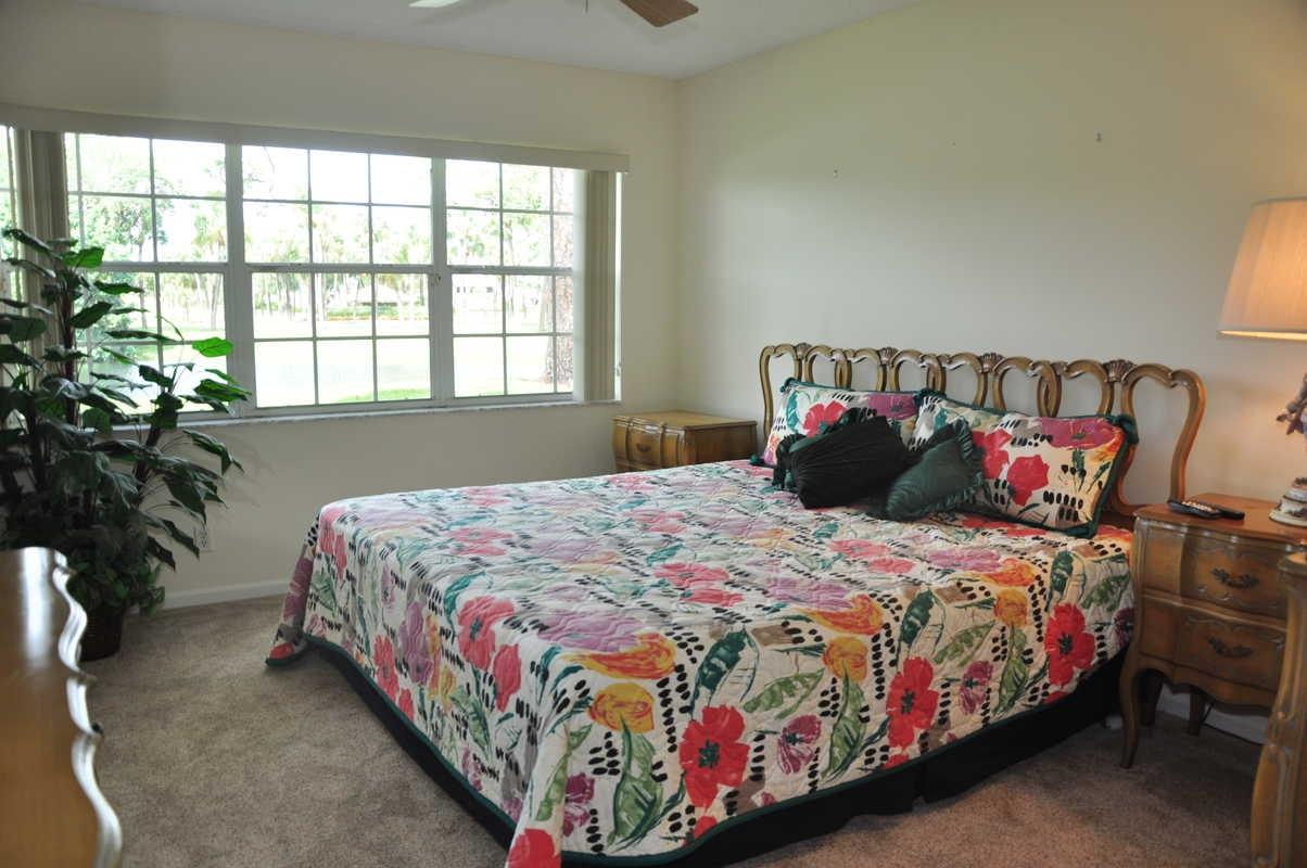 17288 Boca Club Boulevard, Unit 2001 Boca Raton, FL 33487 - Photo 11 of 25 a bedroom with a bed lamp and a potted plant