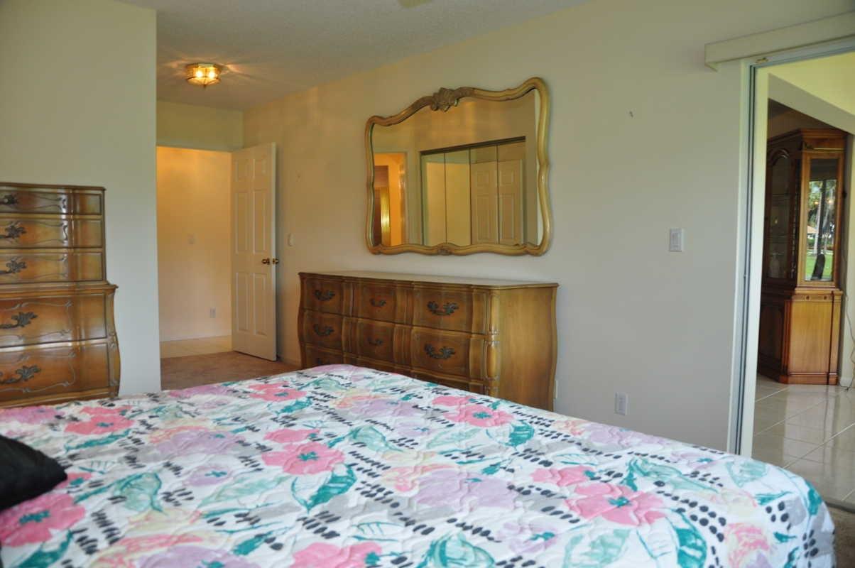 17288 Boca Club Boulevard, Unit 2001 Boca Raton, FL 33487 - Photo 13 of 25 a bedroom with a bed and a mirror