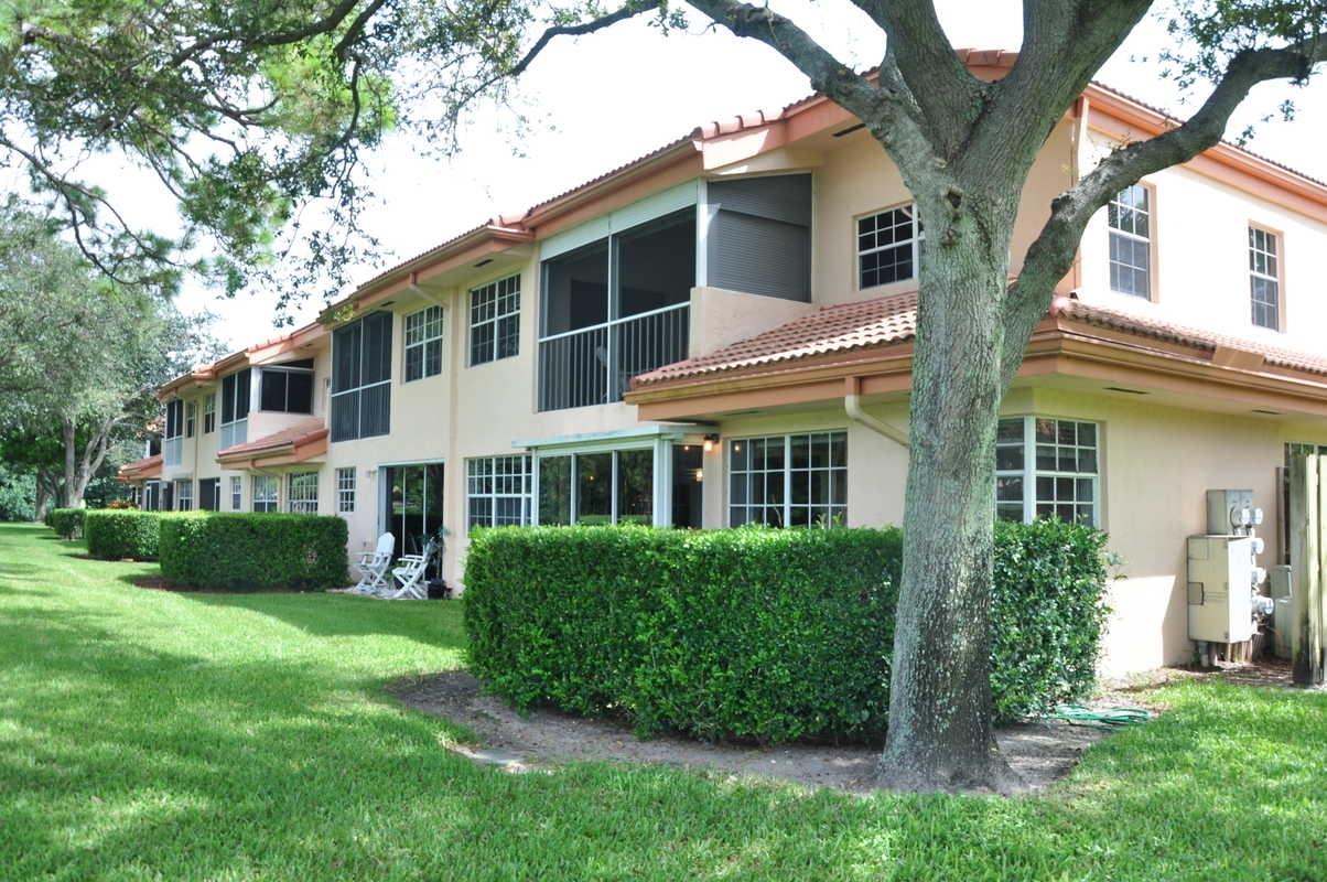 17288 Boca Club Boulevard, Unit 2001 Boca Raton, FL 33487 - Photo 23 of 25 a front view of a house with a yard and potted plants
