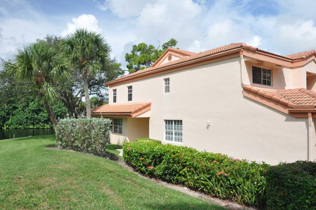 17288 Boca Club Boulevard, Unit 2001 Boca Raton, FL 33487 - Photo 24 of 25 a view of a white house with a yard and plants