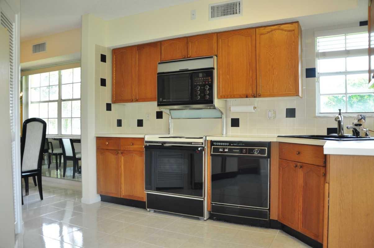 17288 Boca Club Boulevard, Unit 2001 Boca Raton, FL 33487 - Photo 7 of 25 a kitchen with stainless steel appliances granite countertop a stove a sink and a microwave