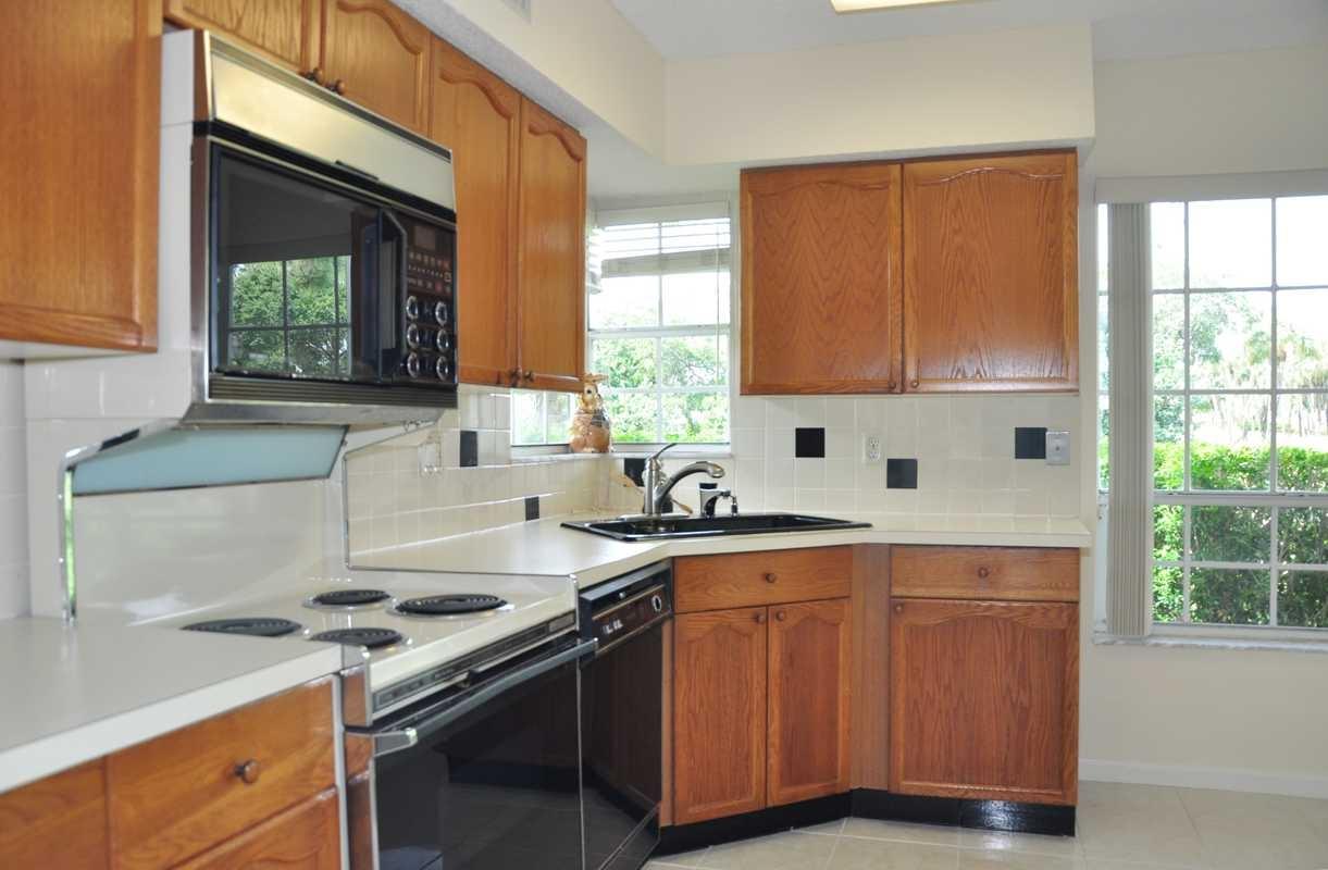 17288 Boca Club Boulevard, Unit 2001 Boca Raton, FL 33487 - Photo 8 of 25 a kitchen with a sink stove top oven and cabinets