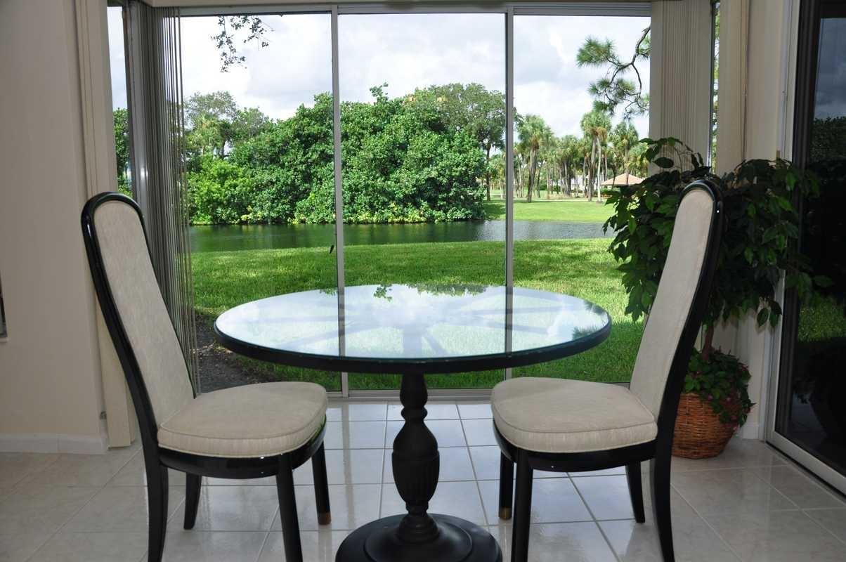 17288 Boca Club Boulevard, Unit 2001 Boca Raton, FL 33487 - Photo 9 of 25 a view of a wooden table and chairs in patio