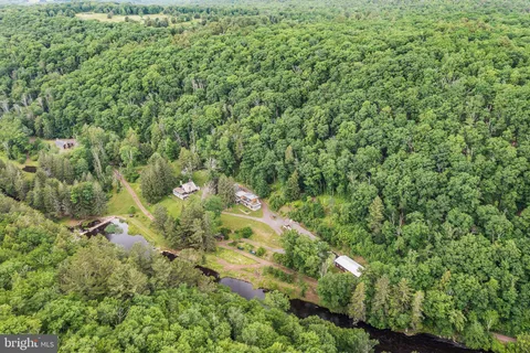 a view of a lake with a house in a forest