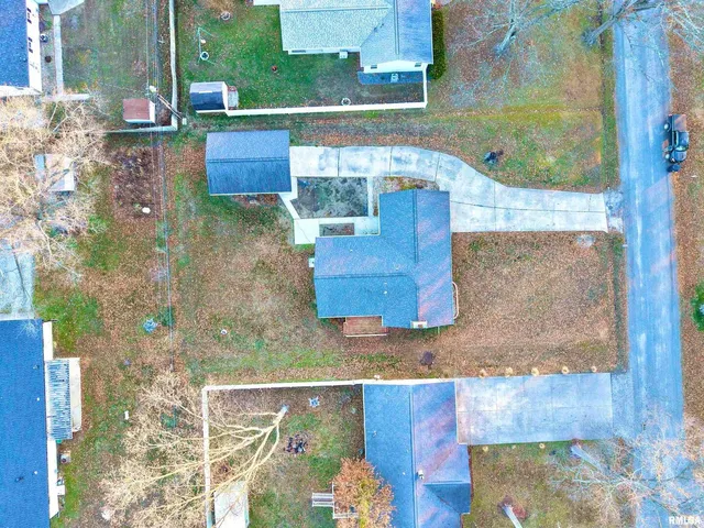 a view of a yard with a house and trees in the background