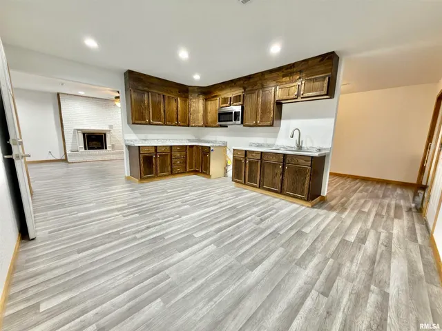 a open kitchen with stainless steel appliances granite countertop a sink dishwasher stove and oven with wooden cabinets