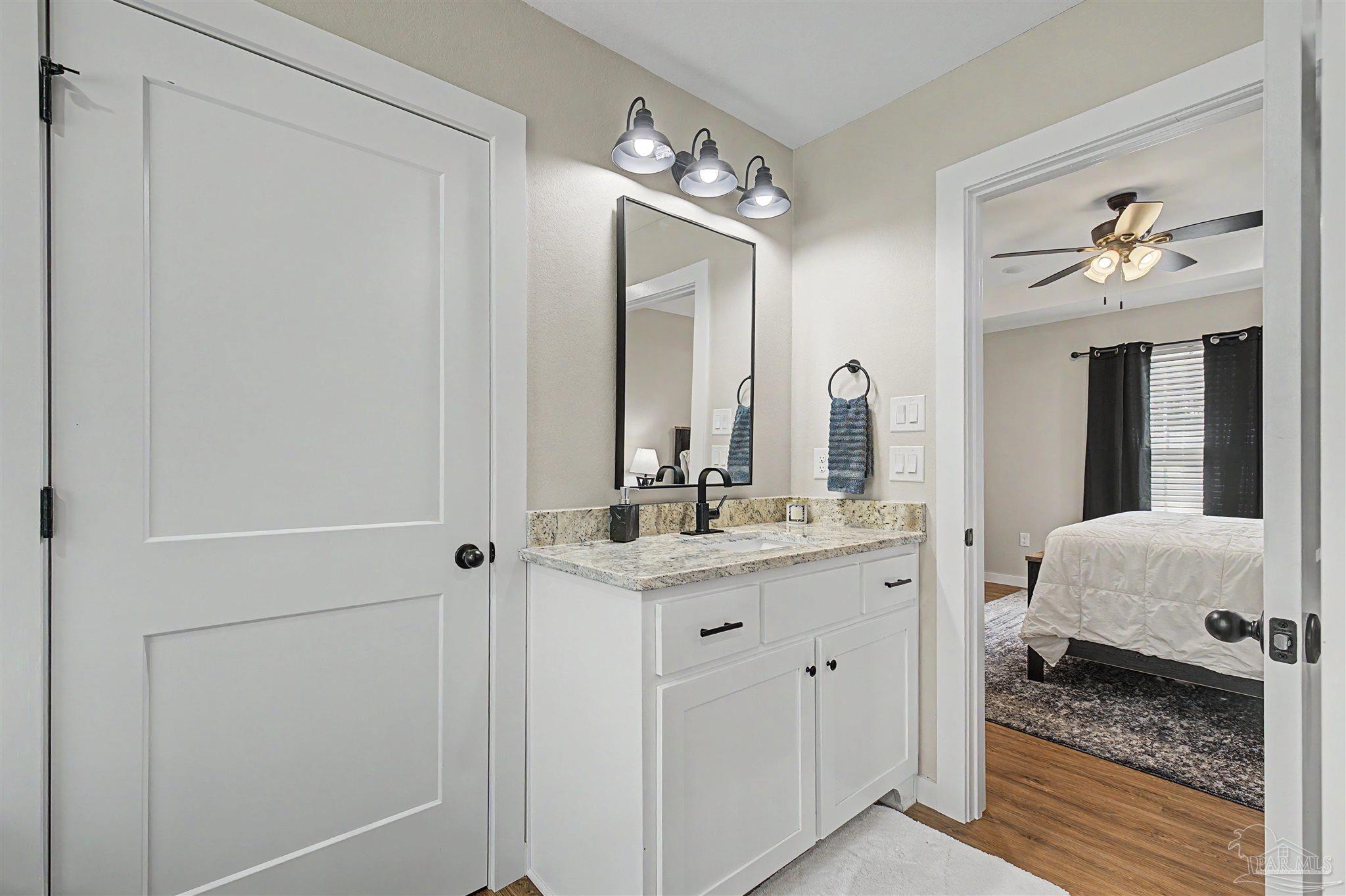 2549 Ten Mile Road Pace, FL 32571 - Photo 33 of 46 a en suite bathroom with a granite countertop sink and a mirror
