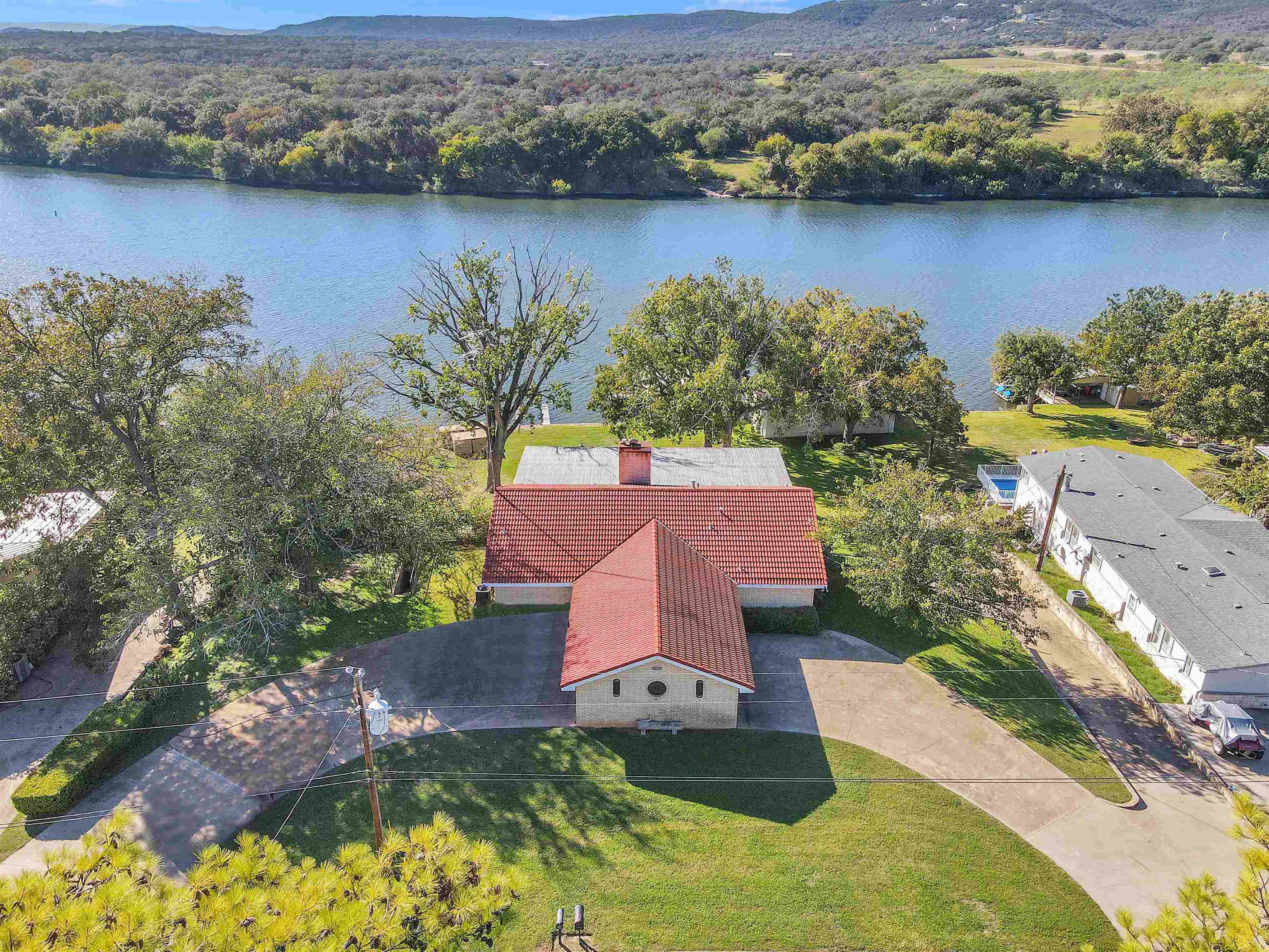 an aerial view of house with yard swimming pool and lake view
