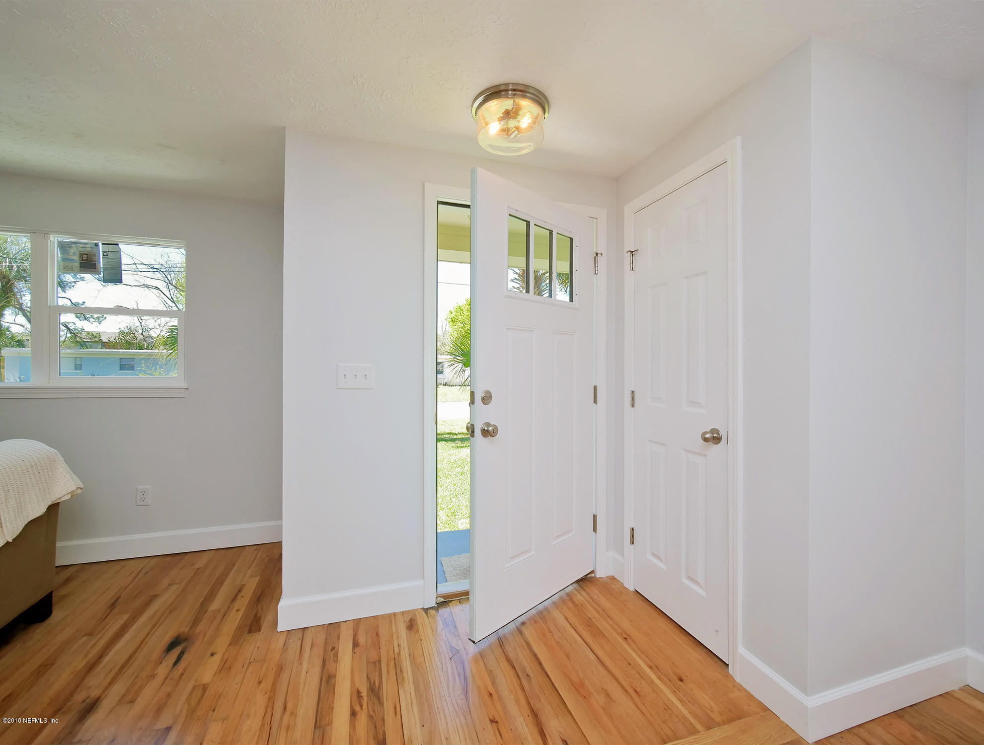 411 Skate Road Atlantic Beach, FL 32233 - Photo 4 of 26 a view of an empty room with wooden floor and a window