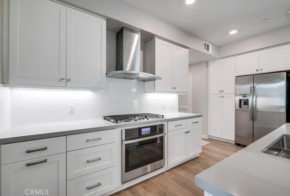 215 Bowery Irvine, CA 92612 - Photo 1 of 63 a kitchen with cabinets stainless steel appliances and wooden floor
