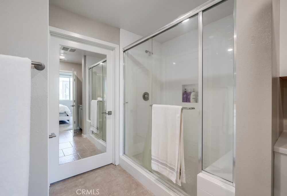 215 Bowery Irvine, CA 92612 - Photo 22 of 63 a bathroom with a glass shower door and a glass door