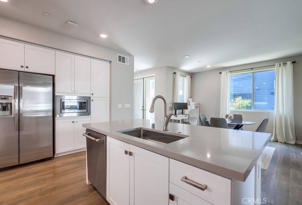 215 Bowery Irvine, CA 92612 - Photo 6 of 63 a kitchen with kitchen island a counter top space a sink refrigerator and cabinets