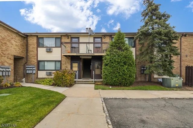 a front view of a house with a yard and potted plants