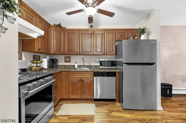 a kitchen with stainless steel appliances granite countertop a refrigerator sink and stove