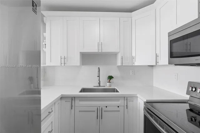 a kitchen with white cabinets and sink