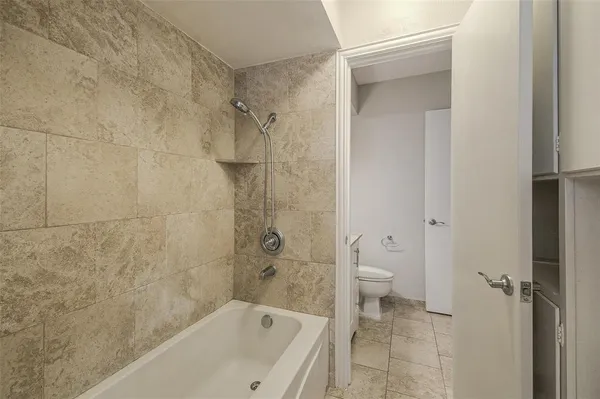 a bathroom with a granite countertop sink a toilet and shower