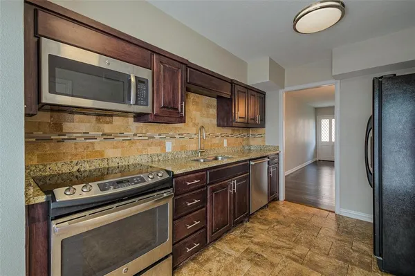 a kitchen with stainless steel appliances granite countertop a stove microwave and refrigerator