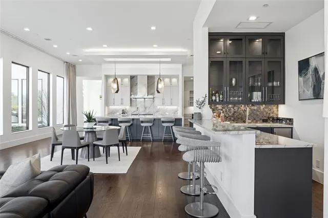 a living room with furniture kitchen and a large window