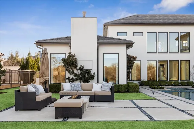 a view of a house and couches with swimming pool in front of house