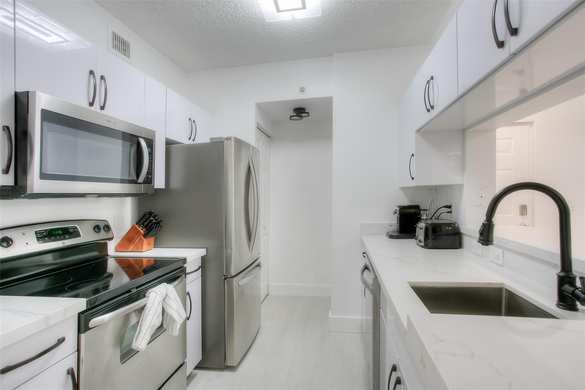 17150 North Bay Road, Unit 2218 Sunny Isles Beach, FL 33160 - Photo 3 of 15 a kitchen with stainless steel appliances granite countertop a sink and a refrigerator