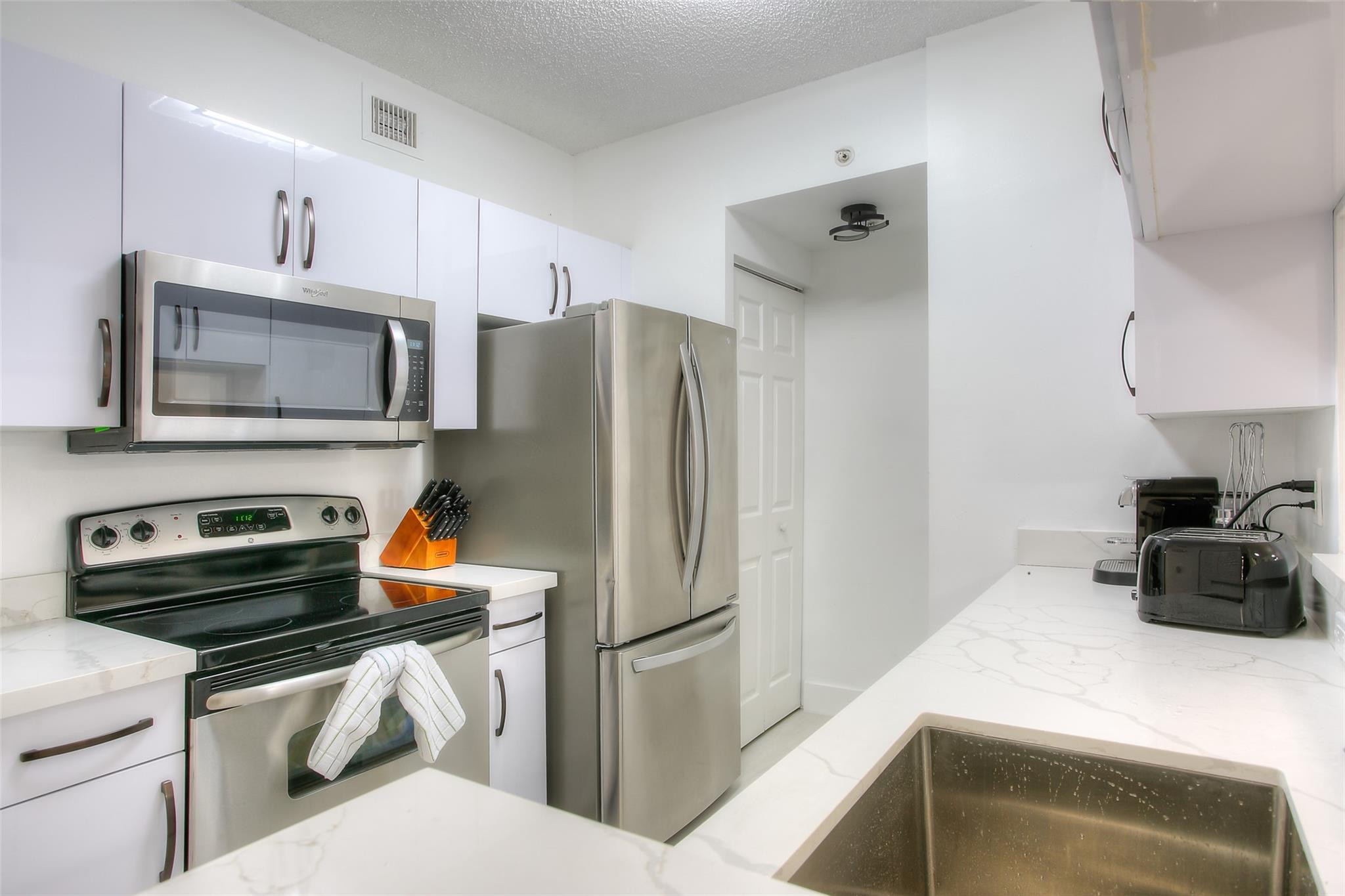 17150 North Bay Road, Unit 2218 Sunny Isles Beach, FL 33160 - Photo 4 of 15 a kitchen with a refrigerator stove and microwave