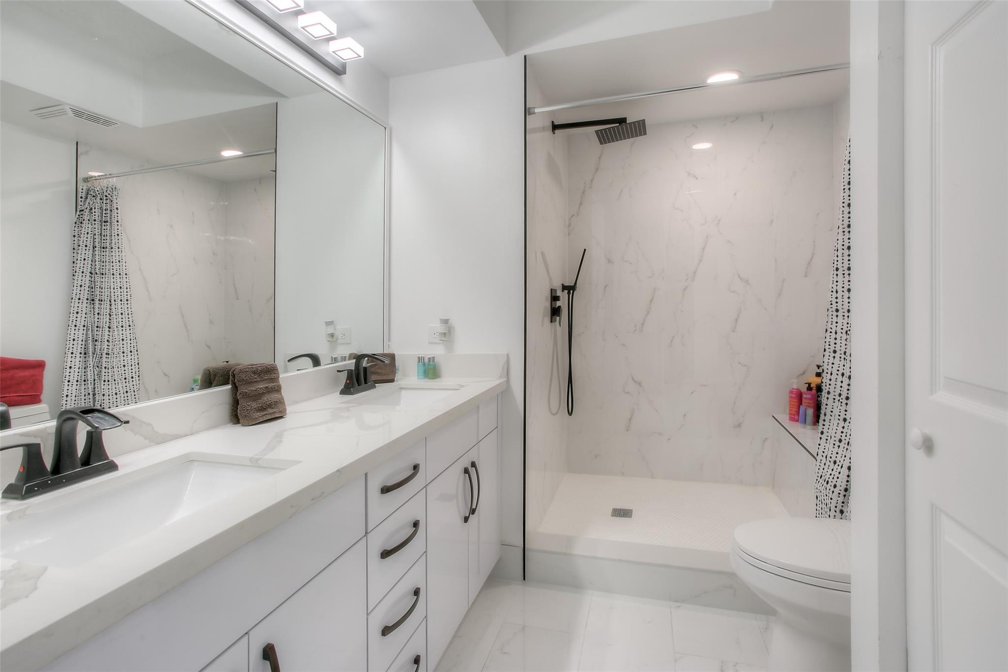 17150 North Bay Road, Unit 2218 Sunny Isles Beach, FL 33160 - Photo 8 of 15 a bathroom with a tub shower sink vanity granite and toilet