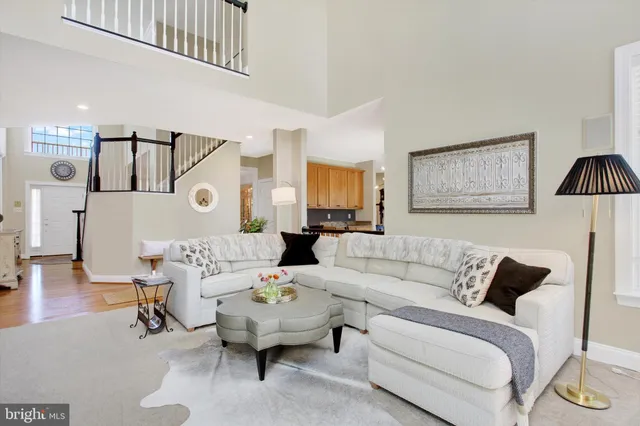 a living room with furniture a fireplace and a chandelier