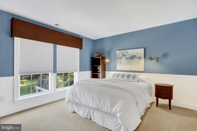 a bedroom with a bed and a mirror on dresser