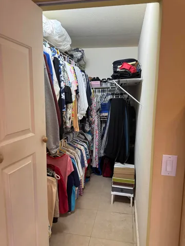 a view of walk in closet with clothes and shoes