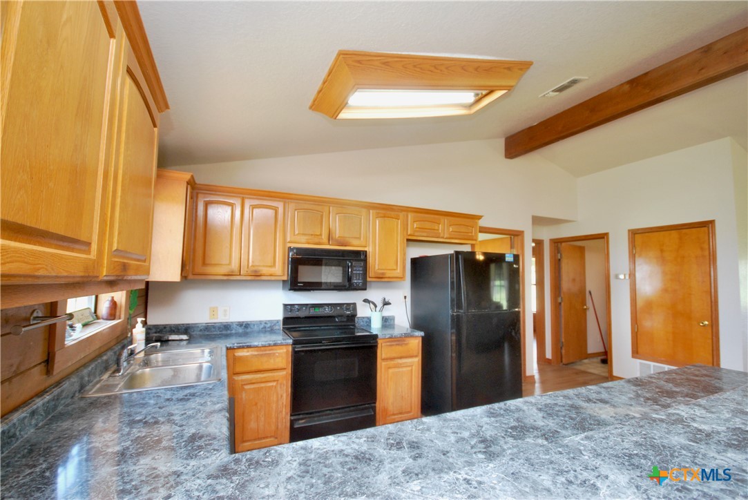 2725 Old Lehmann Road Seguin, TX 78155 - Photo 13 of 47 a kitchen with stainless steel appliances granite countertop a refrigerator a stove and a sink