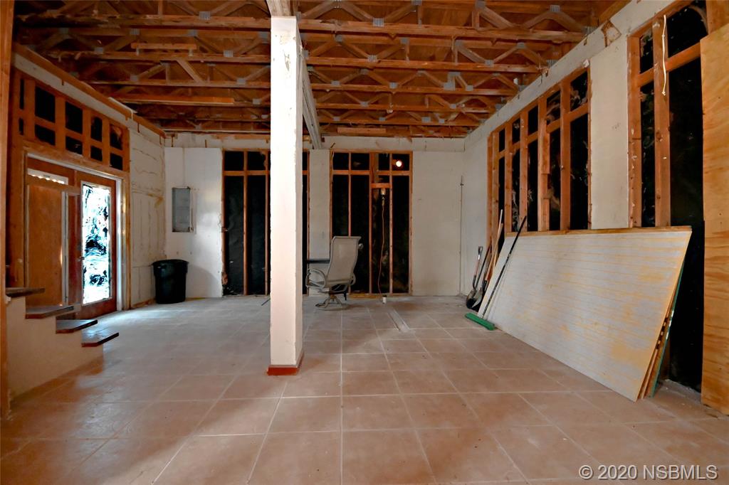 6829 Turtlemound Road New Smyrna Beach, FL 32169 - Photo 9 of 38 a view of a hallway with wooden walls and windows
