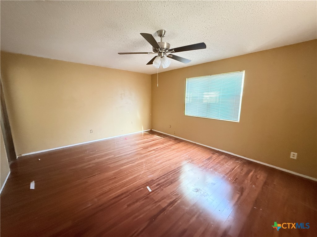 4700 Old Howard Road Temple, TX 76504 - Photo 12 of 33 a view of an empty room with wooden floor and a ceiling fan