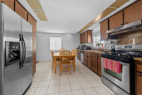 a kitchen with stainless steel appliances granite countertop a stove a sink dishwasher and a refrigerator