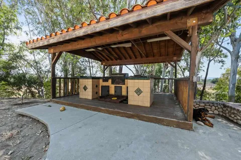 a backyard of a house with barbeque oven and outdoor seating